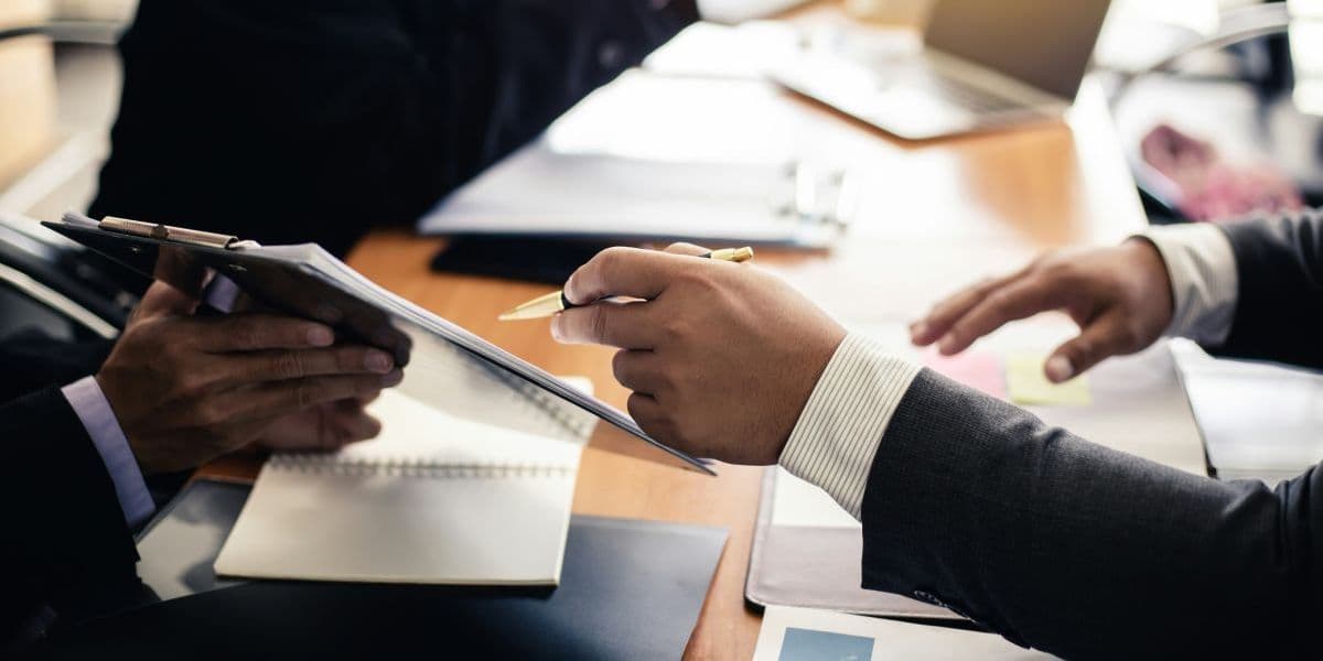 Two professionals discussing training documents during a Bildungsgutschein consultation
